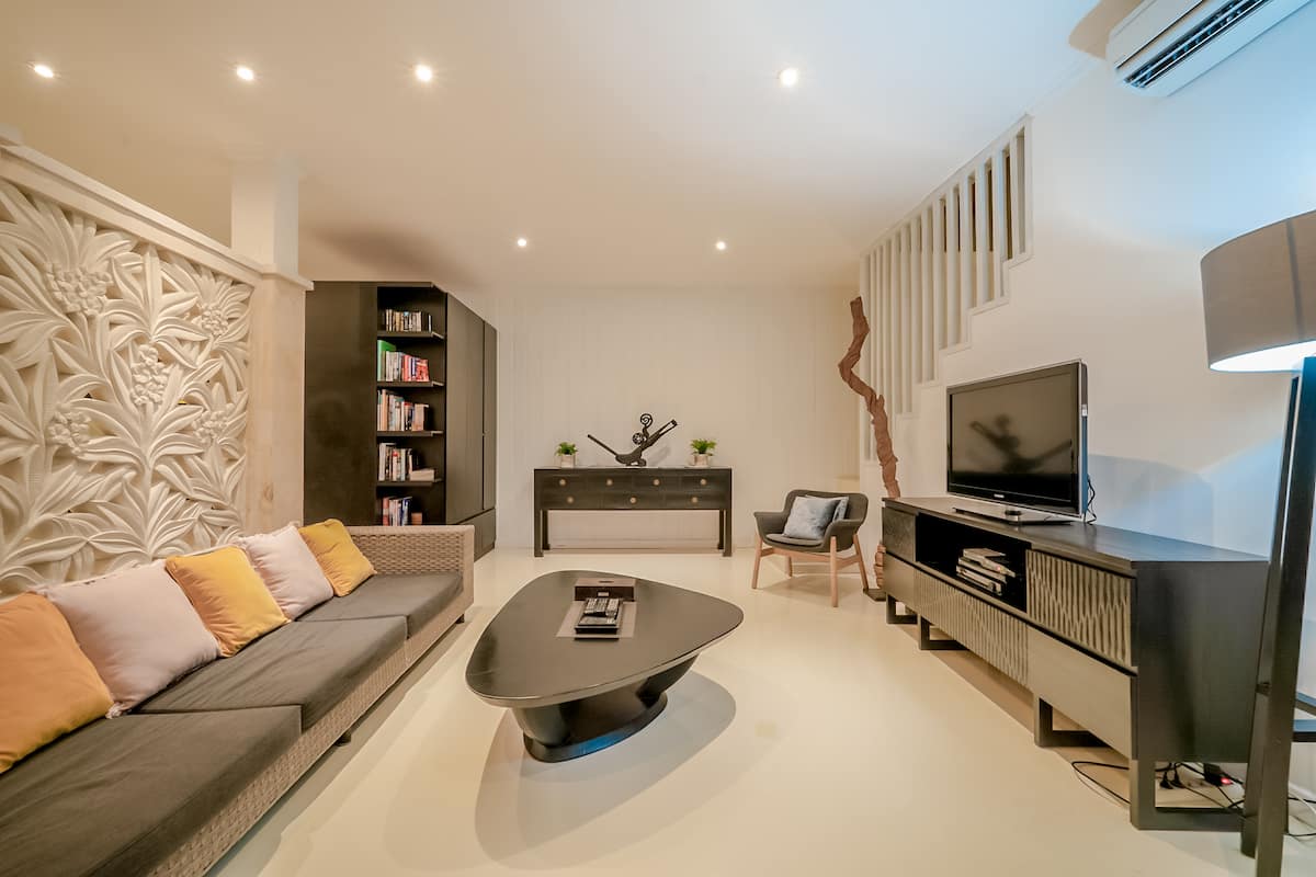 Modern living room w/ plush seating, warm lighting & a TV for cozy nights in