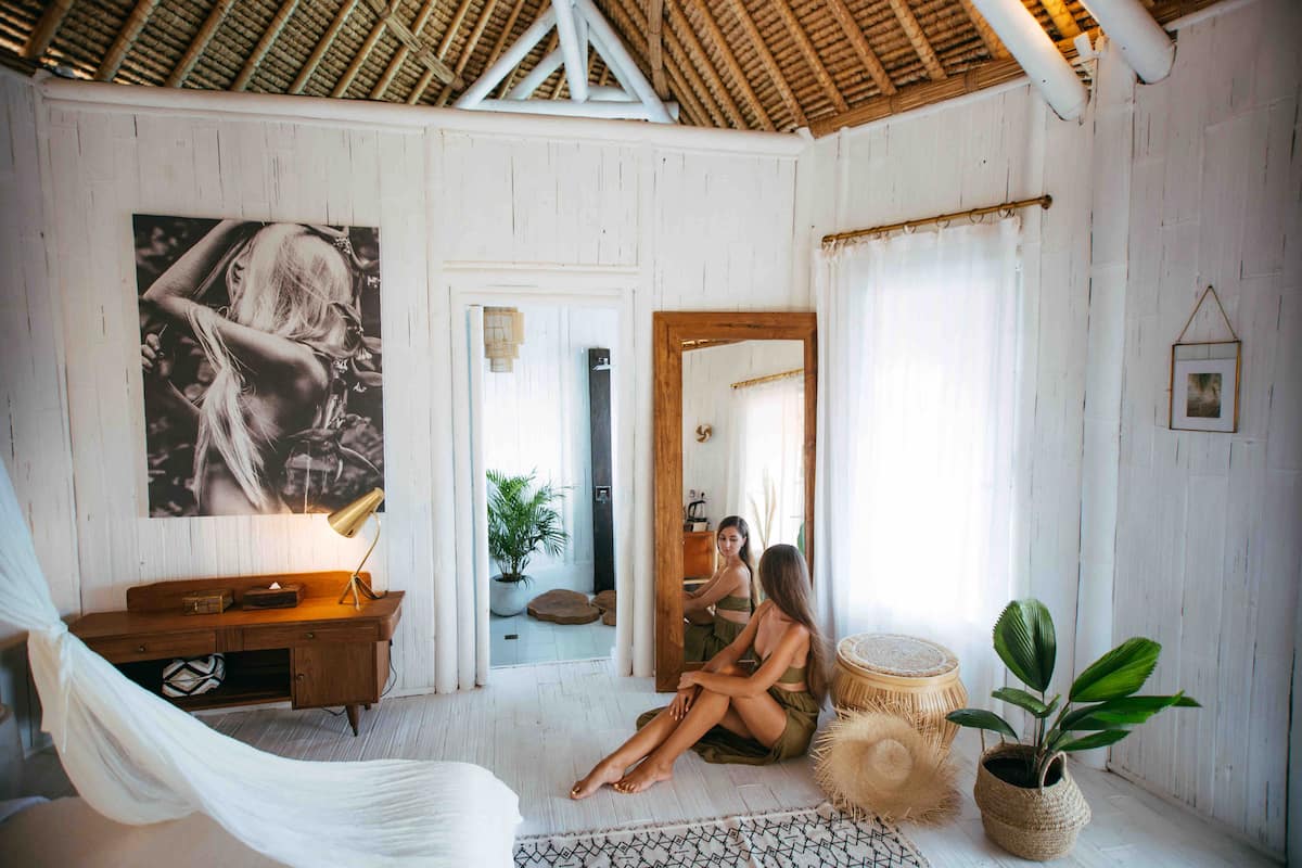 The master bedroom, boasts high ceilings and a bright, airy atmosphere. Thoughtfully designed for comfort, it includes beautiful touches such as a wooden table for your belongings and a large mirror for dressing.